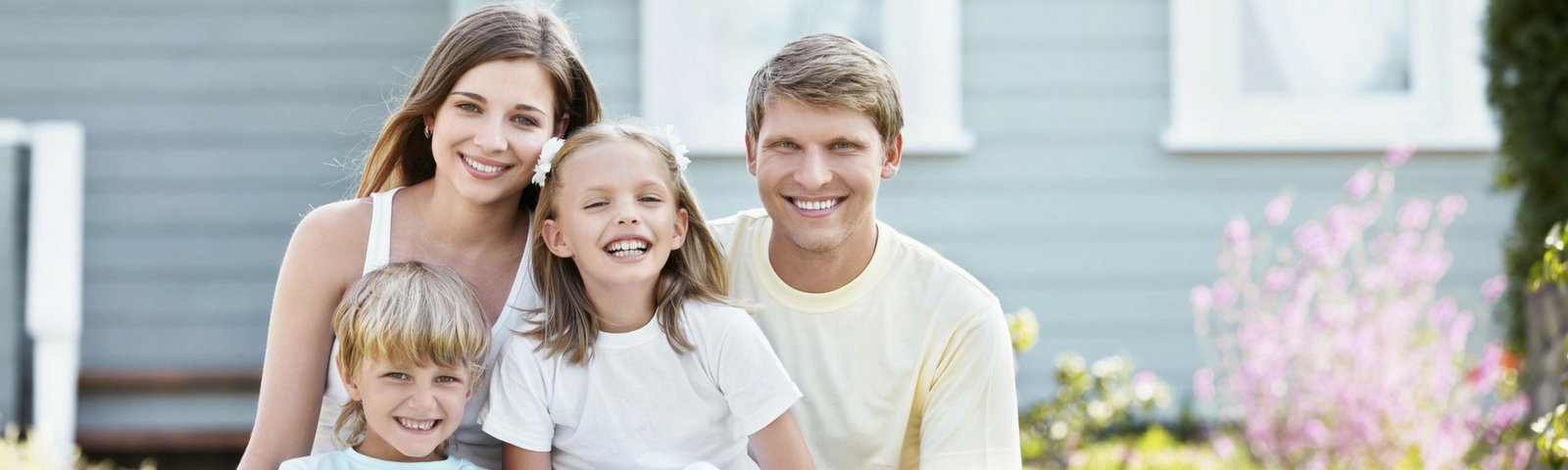 Family smiling outside their home